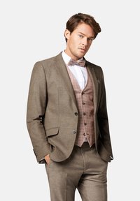 Brauner strukturierter Anzug mit passender Hose und einer Weste mit kariertem Muster. Ein weißes Hemd und eine helle Fliege runden den Look ab.