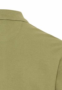Olivenfarvet polo skjorte med ribbet krave og glat tekstur i ensfarvet design, der viser et delvist bagview.