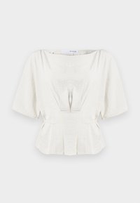 Blusa avorio chiaro con maniche corte, dettagli arricciati e vita peplum. Realizzata in un tessuto testurizzato, presenta delicate pieghe per dare struttura.