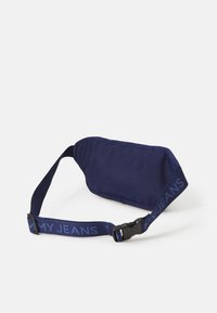 Marsupio navy in tessuto morbido. Presenta una forma curva, una tracolla regolabile con il testo "MY JEANS" e una chiusura con fibbia in plastica.