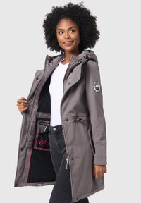 Gray waterproof jacket with adjustable hood, front zippers, and a drawstring waist. Interior features storage pocket with logo accent.