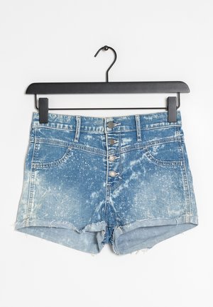 Pantalones cortos de mezclilla con dobladillo deshilachado en azul claro, con un lavado desgastado y patrones moteados, abrochados con cinco botones metálicos.