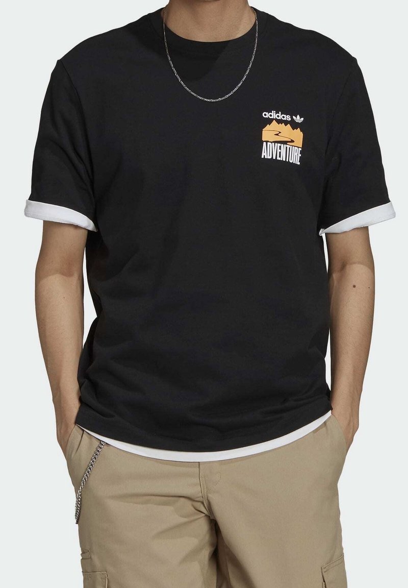 Czarna bawełniana koszulka z białymi podwiniętymi rękawami, z przodu logo na piersi z napisem "adidas ADVENTURE", przedstawiająca góry w kolorze pomarańczowym.