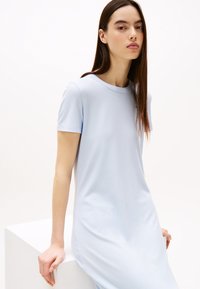Light blue ribbed dress with short sleeves and round neckline. Soft texture and relaxed fit, extending to mid-calf. Simple design, no patterns.