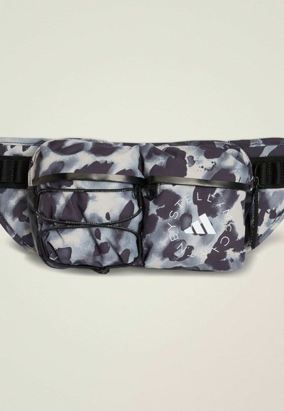 Nerka w szarym i czarnym abstrakcyjnym wzorze. Wykonana z trwałej tkaniny, posiada dwie komory z zamkiem oraz regulowany pasek. Zawiera logo Adidas.