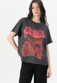 Graues T-Shirt mit kurzen Ärmeln aus Baumwolle, mit einem großen grafischen Design in Pink und Orange, das Blumenmuster und kräftigen Text zeigt.