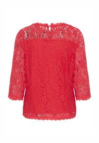 Haut en dentelle rouge avec des manches trois-quarts, ourlet festonné et fermeture par clé au dos. Présente un motif floral sur l'ensemble du tissu.