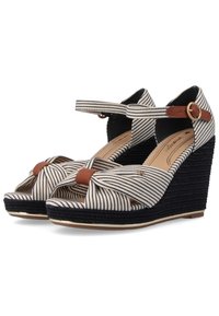 Sandali con zeppa con tomaia in tessuto a righe beige e blu scuro, dotati di una tracolla in pelle marrone e un dettaglio annodato sul davanti.