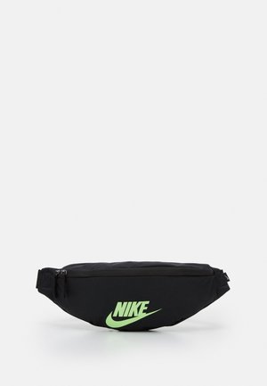 Svart nylon midjeväska med en böjd form, som har en stor grön Nike-logotyp på framsidan och ett dragkedjestängning högst upp.