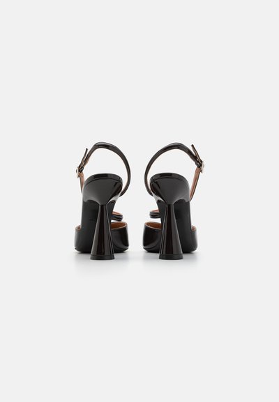 Sorte patenterede læder højhælede sandaler med en kraftig hæl, ankelrem og åben tå-design. Har en glat tekstur og poleret finish.
