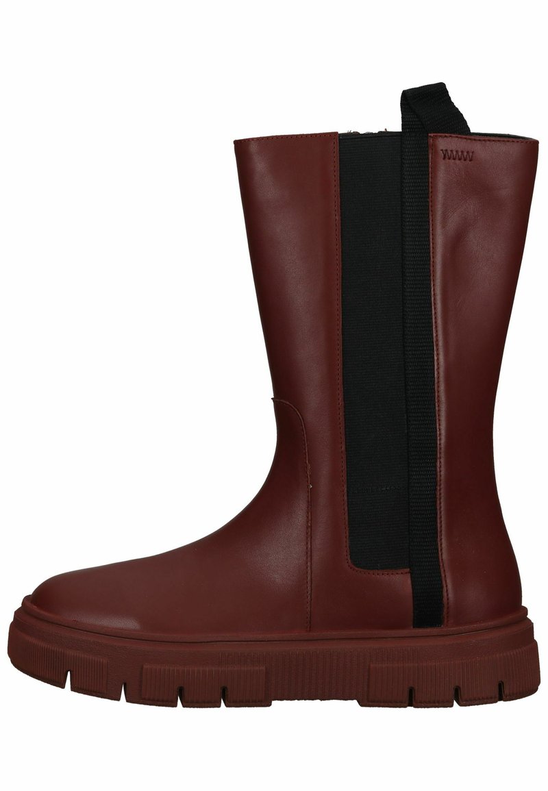 Bota marrón impermeable con un acabado suave, panel lateral elástico y suela gruesa y texturada. Diseño minimalista, altura hasta la pantorrilla.