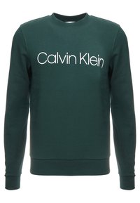 Tmavě zelená mikina s dlouhým rukávem a bílým logem "Calvin Klein" umístěným uprostřed na hrudi, s žebrovanými manžetami a lemem, ve stylu kulatého výstřihu.