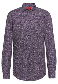 Skjorta med knappar och lång ärm, marinblå bas med blommönster i vitt och rött. Svarta knappar, strukturerad krage och en böjd nederkant.