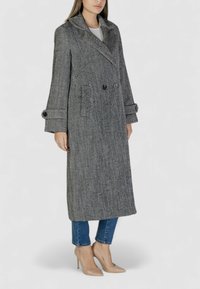 Cappotto grigio a spina di pesce con chiusura doppiopetto, ampi rever e tasche laterali, caratterizzato da maniche larghe e un design lungo fino al ginocchio.