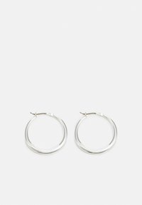 Sølv hoop øredobber har et jevnt, avrundet design med en tynn profil og sikker lås. Minimalistisk stil med en polert finish.