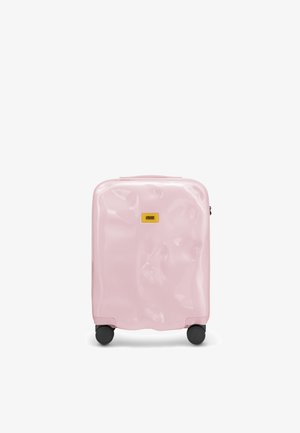 Valigia rigida rosa con una finitura lucida, bordi arrotondati, texture prominente e ruote nere. Presenta una forma rettangolare e una placca con il logo.