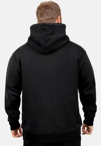 Felpa nera con un ampio cappuccio regolabile, polsini e vita a costine. Tessuto morbido, colore solido, design minimalista, senza motivi visibili.