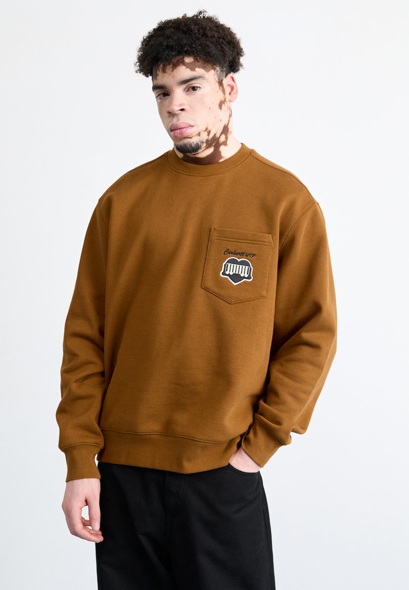 Sudadera marrón con cuello redondo y mangas largas. Presenta un bolsillo frontal con detalles gráficos y puños y dobladillo acanalados.