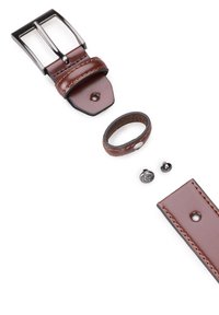 Brązowy skórzany pasek z metalową klamrą w kolorze srebra, dopasowaną taśmą oraz dwoma dekoracyjnymi ćwiekami. Skóra ma kontrastowe detale w postaci przeszyć.