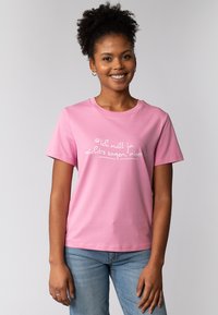 Rosa Baumwoll-T-Shirt mit kurzen Ärmeln, mit weißem Text auf der Vorderseite, der "Ich will ja nichts sagen, aber..." lautet.