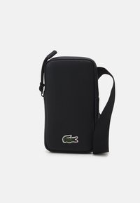 Borsa nera e rettangolare con una superficie testurizzata, tracolla regolabile e logo di coccodrillo verde ricamato sul davanti. Realizzata in materiale resistente.