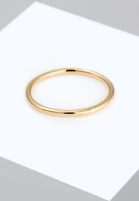 Gouden metalen ring met een gladde, gepolijste afwerking. Cirkelvormig met een uniforme breedte en zonder versieringen.