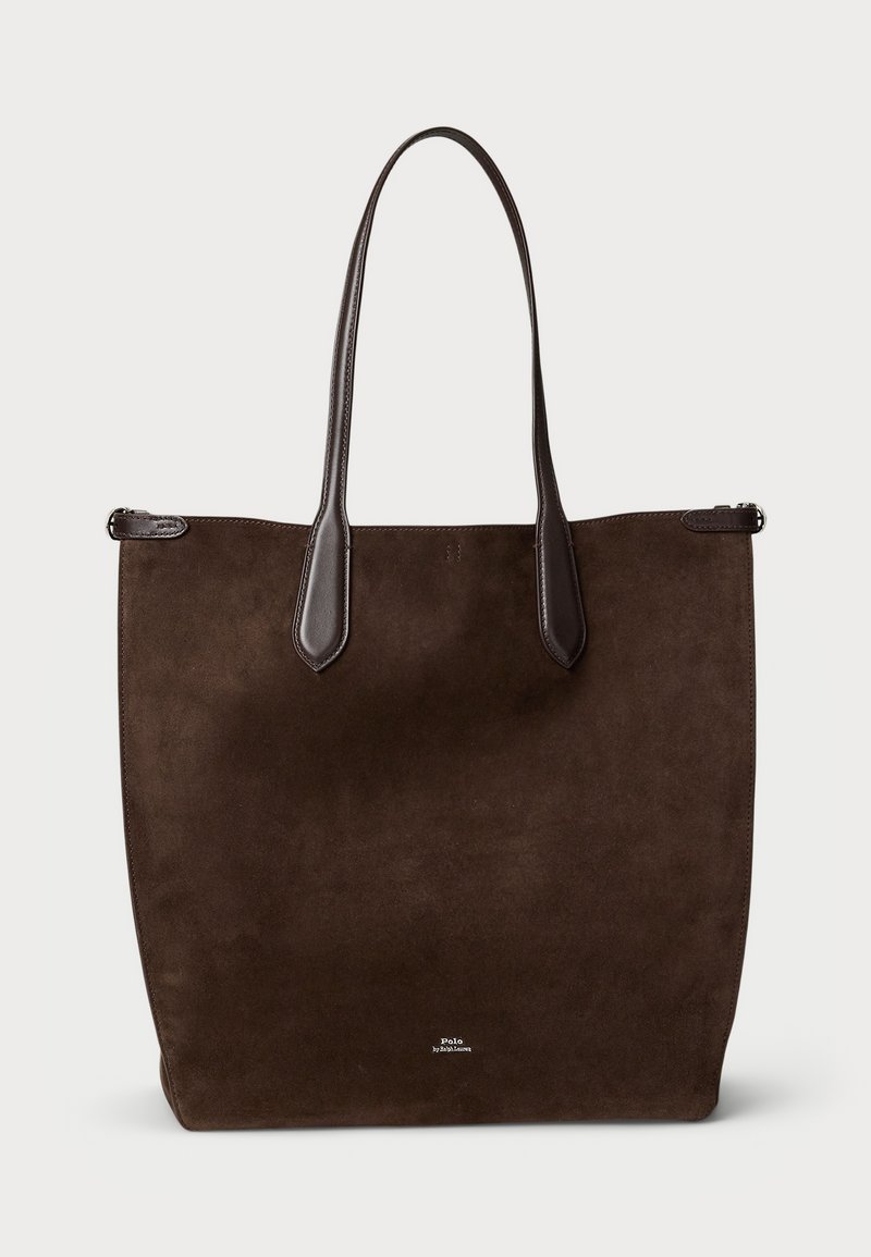 Sac fourre-tout en daim marron avec des accents en cuir noir, deux longues poignées et un design minimaliste. Présente un logo de marque visible sur le devant.