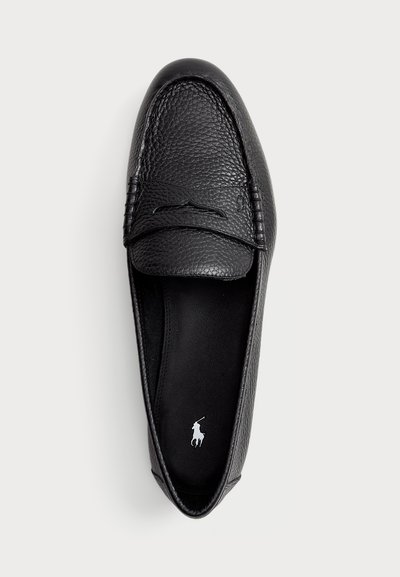 Black leather moccasin with textured surface, rounded toe, and decorative stitching. Features a contrasting insole logo.