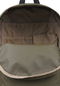 Mochila de tela verde oliva con una textura suave. El interior cuenta con bolsillos, incluido uno de malla. Solapa plegable con un borde cosido.