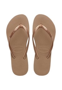 Ζευγάρι μπεζ υφασμένα σανδάλια Havaianas με λεπτά μεταλλικά λουράκια και όνομα επωνυμίας χαραγμένο στις σόλες και στα λουράκια.