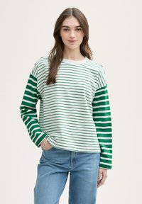 Camiseta de manga larga a rayas en blanco y verde, con franjas de diferentes anchos. Material de algodón suave, corte relajado, cuello redondo.