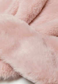 Rosa imiteret pelsstof med en blød, fluffy tekstur. Materialet ser tykt og fyldigt ud og har en blid glans på overfladen.