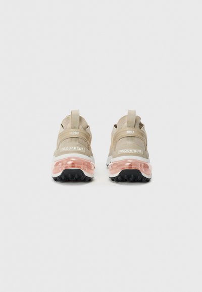 Sneakers beige con tomaia in rete e materiale sintetico, suola intermedia bianca, suola traslucida rosa e linguette posteriori. Presentano il marchio e l'anno "1964".