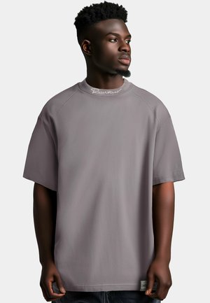 Grijze oversized t-shirt met een ronde hals, raglanmouwen en een subtiele logo nabij de halslijn. Huidige textuur met een comfortabele pasvorm.