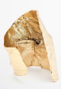 Scultura astratta tono oro con superficie testurizzata, caratterizzata da pieghe e piegature. Presenta il marchio “Massimo Dutti” all’interno.