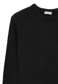 Schwarzer, langärmeliger Pullover aus strukturierter, gerippter Stoffqualität mit Rundhalsausschnitt. Das Etikett trägt die Aufschrift "CALLIOPE" mit Größenangabe.