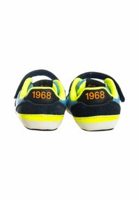 Sneaker blu navy con accenti giallo neon e tallone in tessuto nero. Presenta il numero 1968 in arancione sul retro e cinturini in Velcro per la chiusura.