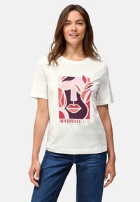 Camiseta de algodón blanca con un estampado gráfico de rostros abstractos y hojas en tonos rojos y rosas, con el texto "APERITIVO CLUB AMALFI COAST".