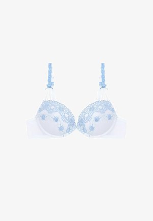 Bílá krajková podprsenka s jemně modrými květinovými výšivkami, měkkými košíčky a nastavitelnými ramínky. Má vlnkovaný krajkový lem na vrchu.