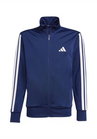 Giacca sportiva blu navy in tessuto liscio, con collo alto, cerniera frontale integrale e dettagli a strisce bianche sulle spalle.