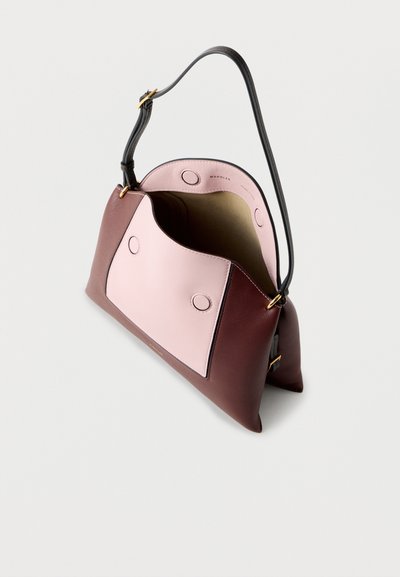 Sac à main en cuir bicolore marron et rose avec une bandoulière noire réglable, ouverture supérieure et doublure intérieure beige visible sur un fond blanc.