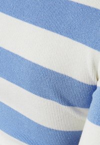 Blå och vit randig ribbstickad tröja med växlande breda ränder, som visar upp ett texturerat tyg och en figurnära design.