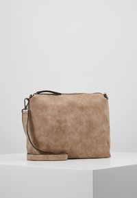 Tan kunstmocka skuldertaske med lynlås, justerbar rem og glat tekstur. Rektangulær form med minimalistisk design.