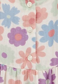 Tessuto a fantasia floreale con grandi margherite nei colori blu, rosa, verde e viola, con bottoni bianchi lungo il davanti. Materiale leggero.