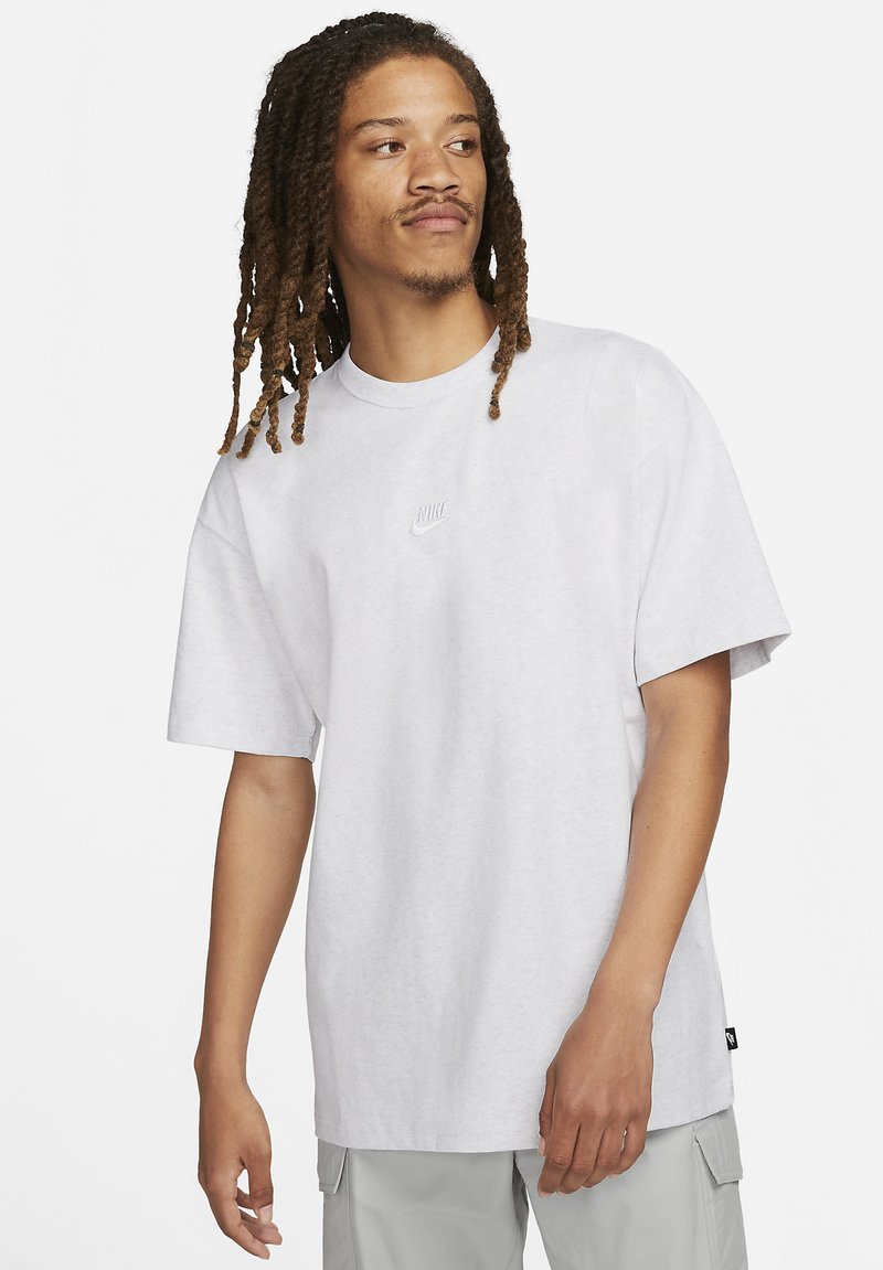 Grijze katoenen t-shirt met een ronde hals en korte mouwen. Voorzien van een subtiel reliëf Nike-logo op de borst en een ontspannen pasvorm.