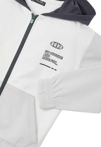 Felpa bianca con zip e cappuccio blu scuro, con la scritta nera "ESCI E DIVERTITI_" e un graphic di un globo. Tessuto morbido, polsini elasticizzati.