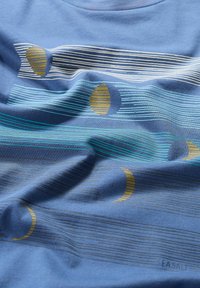 Kortärmad blå T-shirt med vågiga ränder i vitt och teal, med gula cirkulära detaljer. Mjuk bomullsmaterial med en avslappnad textur.