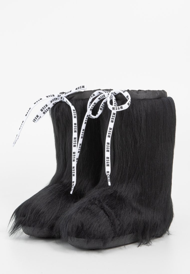 Hoge zwarte vachtlaarzen met witte trekkoordveters en zwart MSGM-logo, weergegeven tegen een effen witte achtergrond.