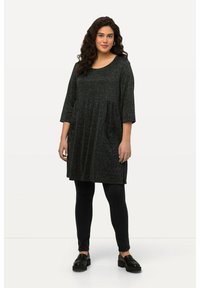 Tunique gris foncé à manches courtes, décolleté arrondi et taille froncée. Portée sur des leggings noirs et des chaussures noires à semelles épaisses. Texture lisse.