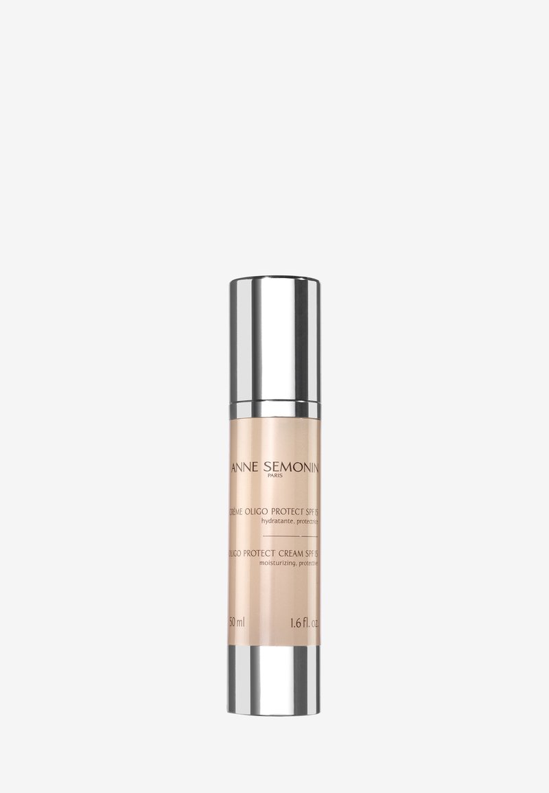 Pumpflaska med kräm med en metallisk silverkapsyl och en beige kropp. Etiketten innehåller "Oligo Protect Cream SPF 15", vilket indikerar återfuktande egenskaper.